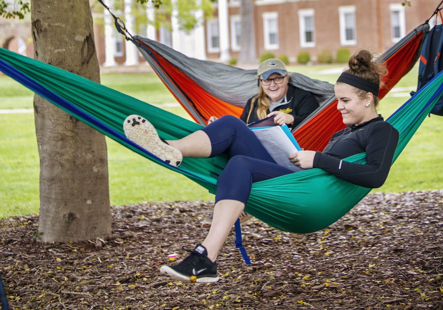 Two students in hammocks studying