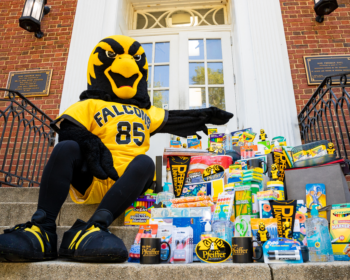 Pfeiffer mascot sitting on steps with care package