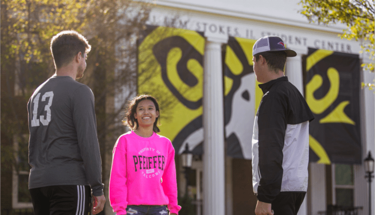 Three students talking outside Pfeiffer student center