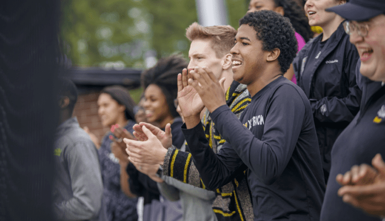 students smiling and clapping