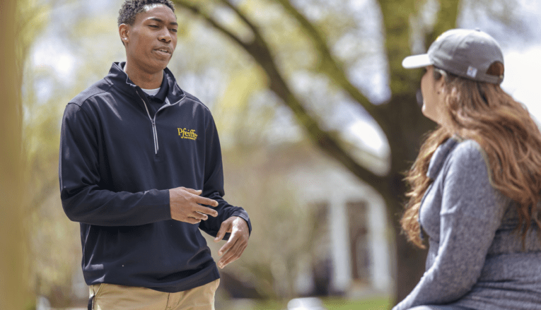 male student talking to female student outside