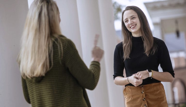 two women standing and talking outside