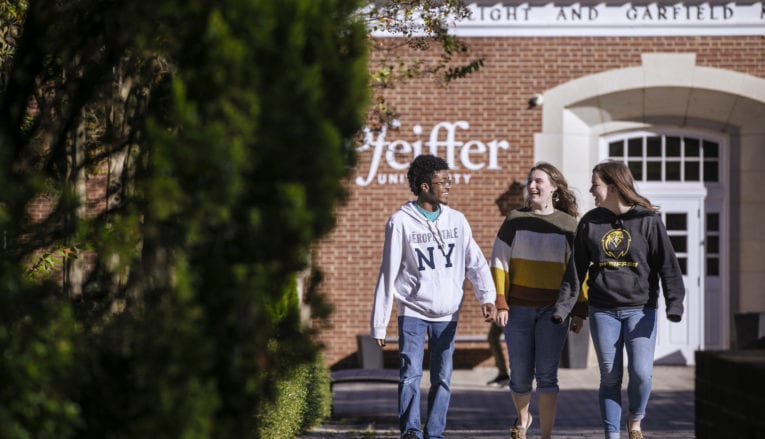 Three students walking on Pfeiffer campus