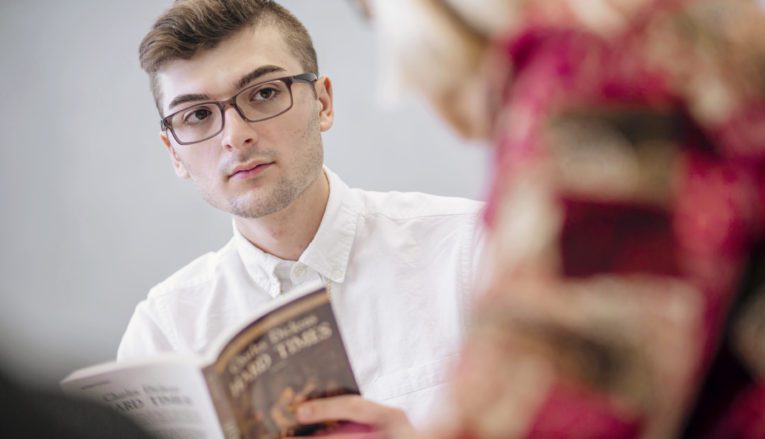 Student in class with book in hand