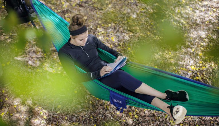 student studying outside in hammock