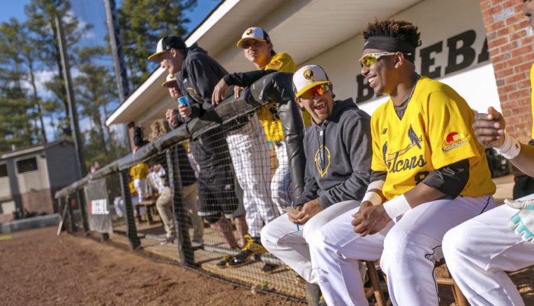 Pfeiffer baseball players sitting in dugout