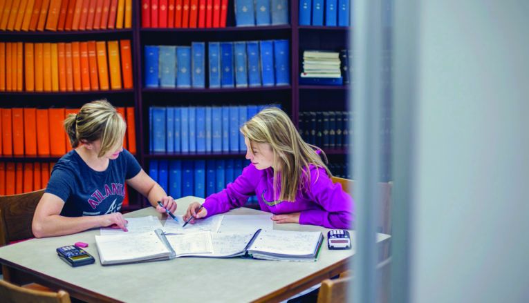 Two students studying together in library