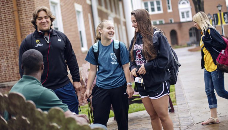 Group of students talking and smiling outside