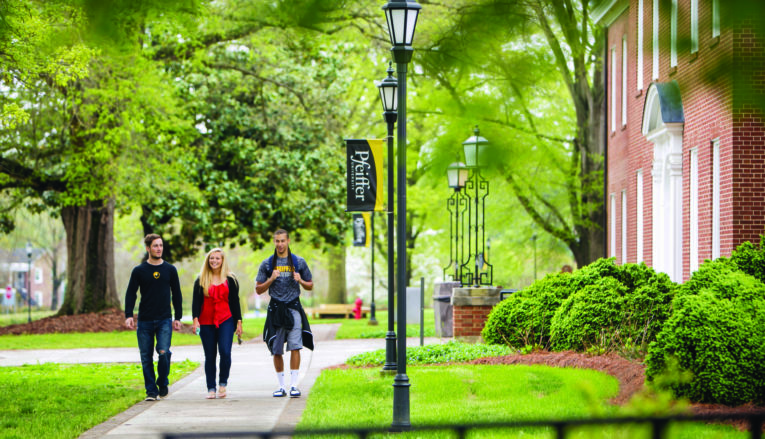 Three students walking on sidewalk on Pfeiffer's campus