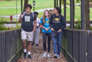 Students talking as they walk across a bridge